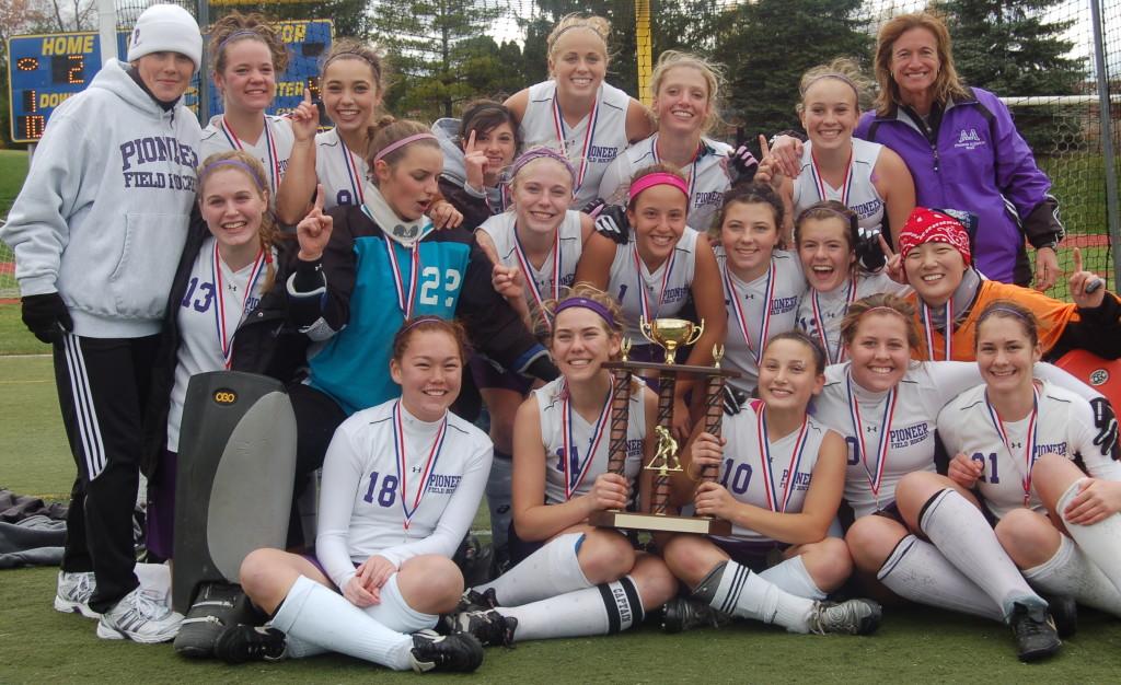 Eliza Stein and the Pioneer field hockey team hoist a state championship trophy for the fifth straight year.
