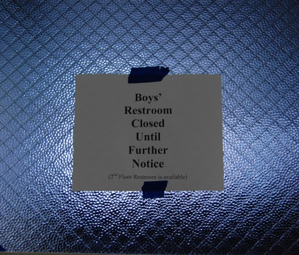 A note hangs on the boys bathroom window announcing the closure.