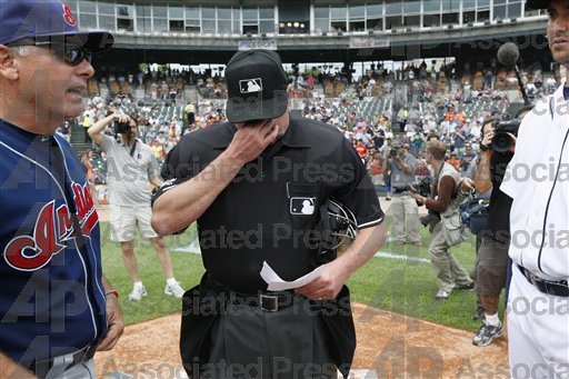 Jim Joyce wipes away tears as he receives lineup cards from Cleveland coach Tim Tolman and Galarraga one day after his blown call.