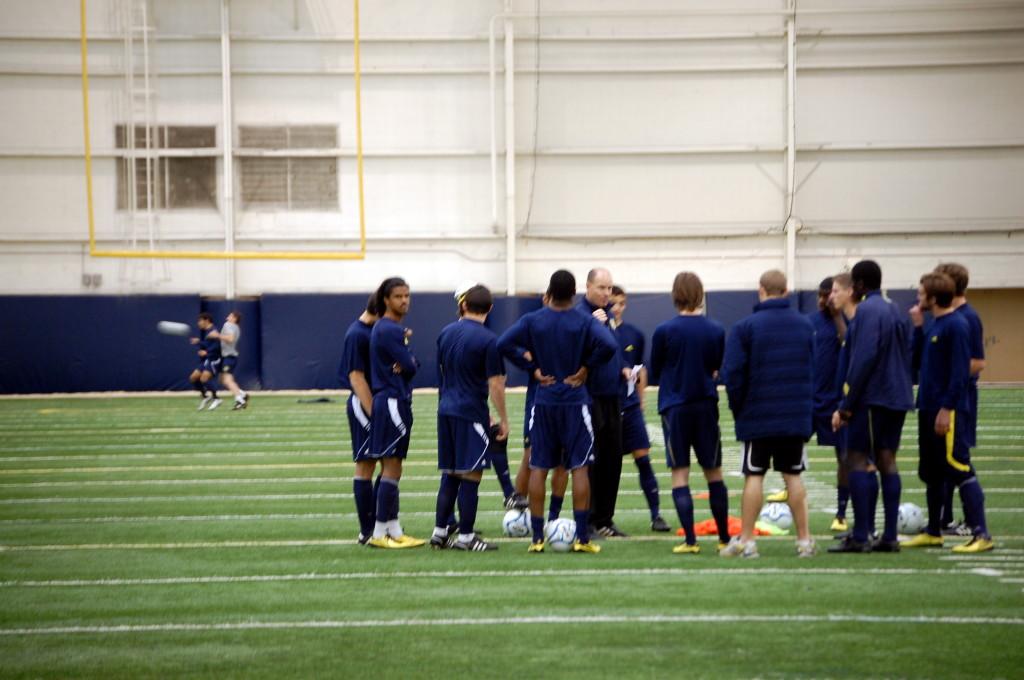 Burns talks to players while preparing for a practice.