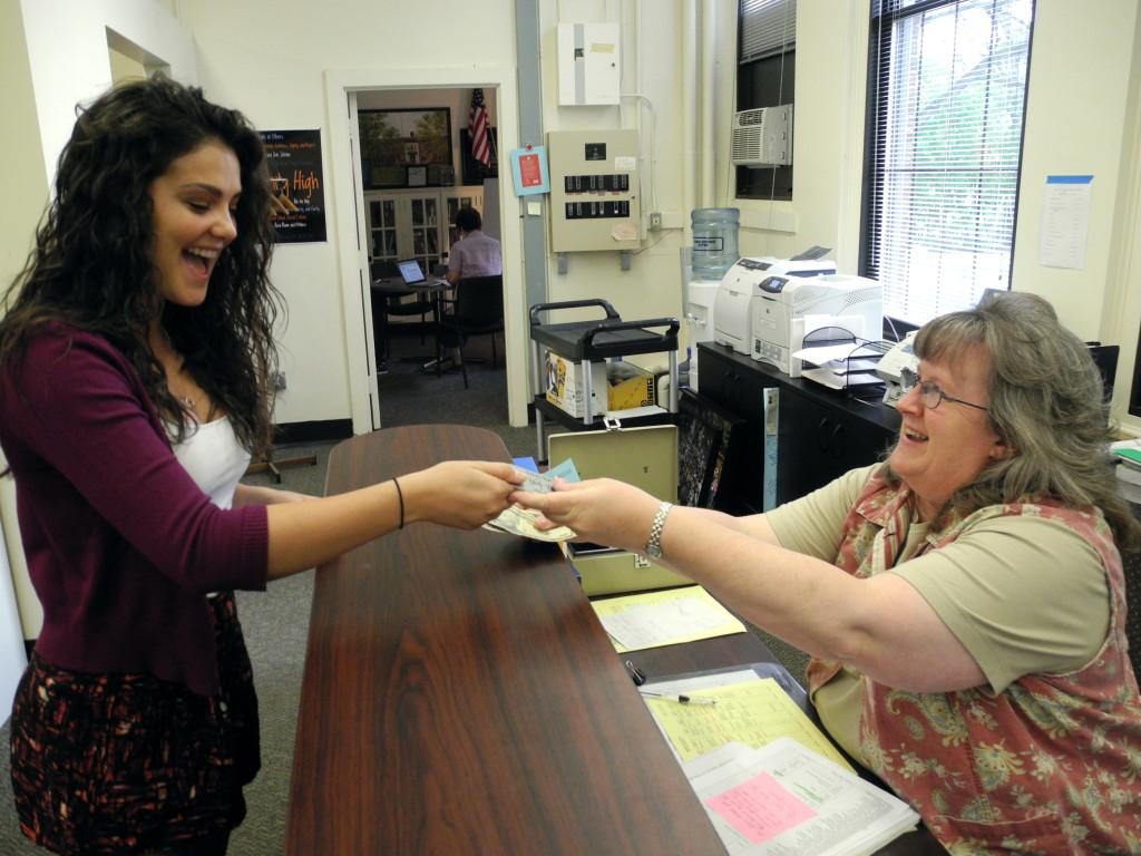 Community High School junior Carly Paull-Baird buys her prom ticket in the main office from Chris Hicks.