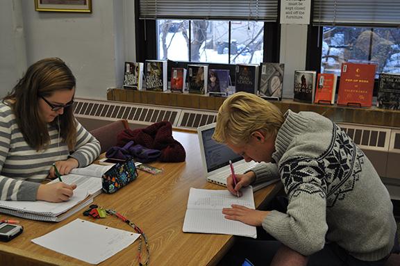 Students study hard while sitting in the library for lunch detention.