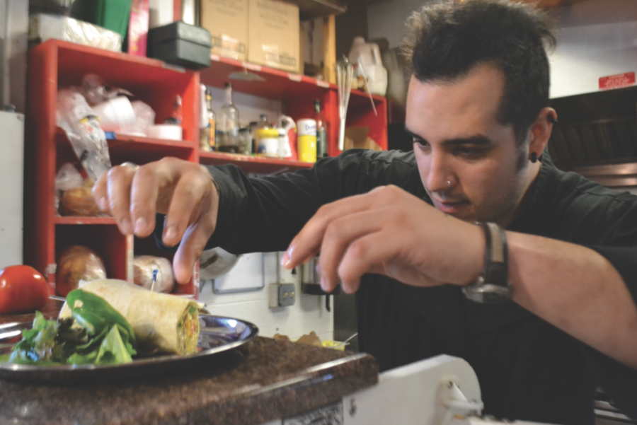 Gregorio DiMarco displays his gregarious personality while putting the finishing touches on the Breakfast Burrito in Sparrow markets kitchen.
