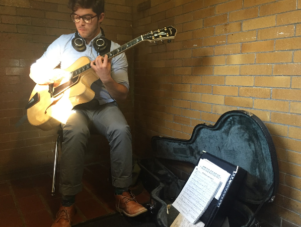 Aidan Cotner sits in the sunlight below the staircase, putting his own twist on Duke Ellington.