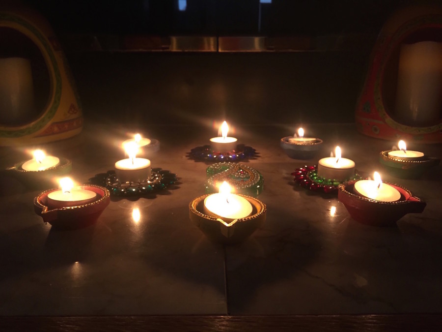 Candles called "diyas" lit for Diwali under a picture of Maha Lakshmi.