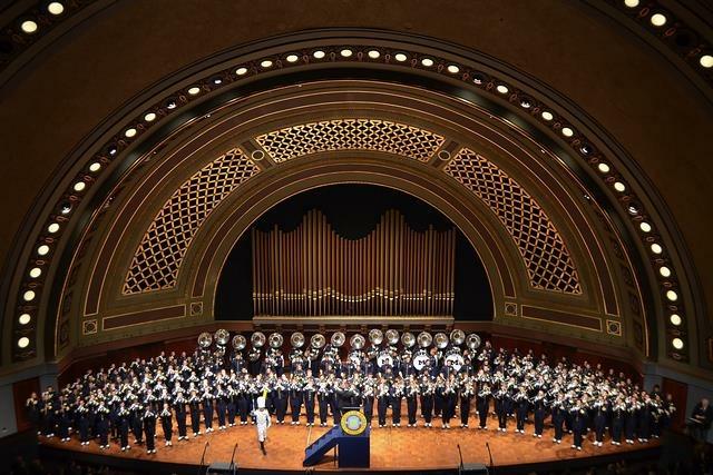 The Michigan Marching Band plays on Hill Auditorium as the Drum Major, Matt Cloutier, directs in front. 