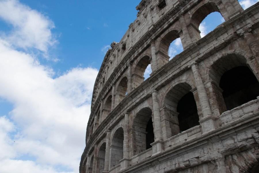 The Colosseum stands tall against blue skies in Rome.