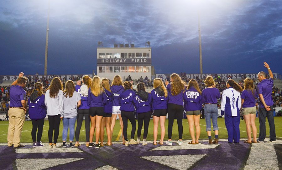 The team stands on the field at the high school football game on Friday,