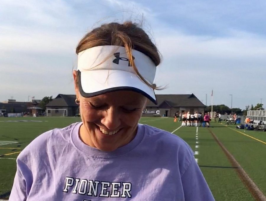 Kim Waddell, in a good mood after Pioneer Field Hockeys win over Grosse Pointe South, stands in front of Pioneer High Schools Hollway Field. Waddell, who played both field hockey and softball in college, now coaches both at Pioneer. Waddells happiness after the game conveys one of her main coaching principles: that the people in leadership roles should always set an example of desire to be there [and be] enthusiastic to be there.