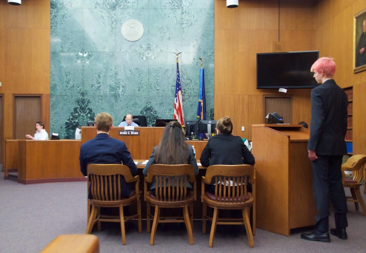 Miles Klapthor, Cammi Tirico, and Martha Ribant listen as Wilson Gipson cross examines witness, Geneve Thomas-Palmer. Klapthor, Tirico, and Ribant are on Community B team and Gipson is on Community A team.