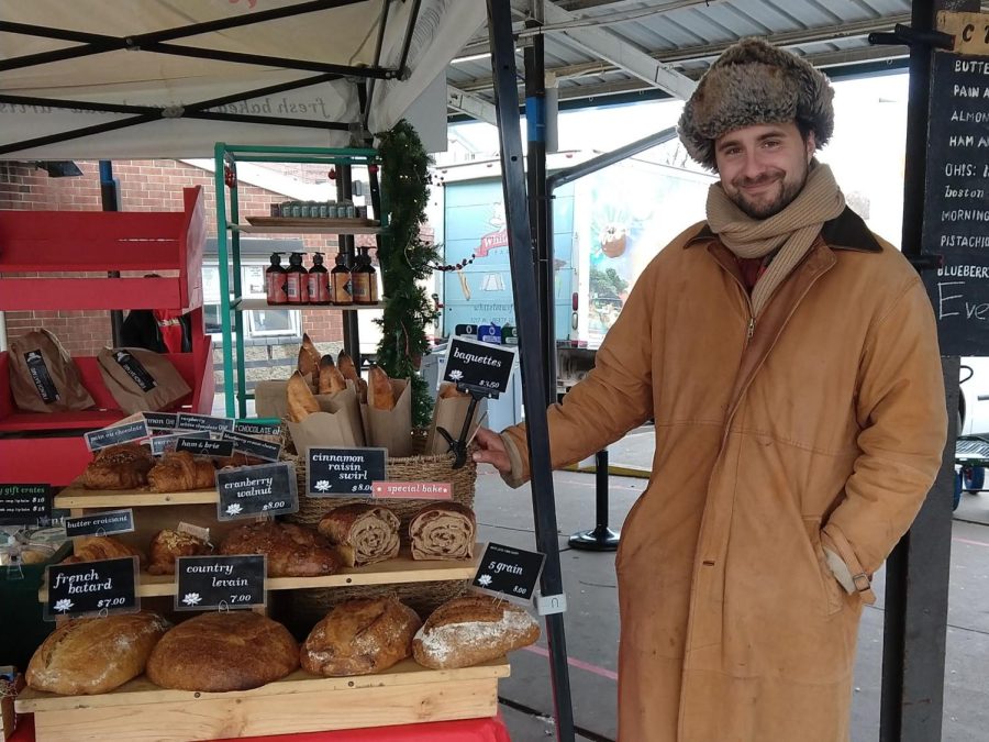 Byron Johnson next to the White Lotus Farms stall at the Farmers Market.