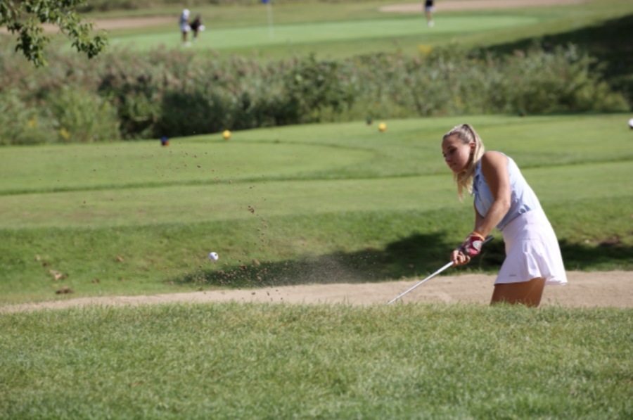 Alana Eisman hits her ball out of a sand trap at Lake Forest Golf Course on Sept. 13 at a match against Pinckney High School. Eisman has been competing for Skyline High School since her freshman year. “I feel like all the hard parts in golf are worth it if you have good people surrounding you and supporting you, Eisman said.