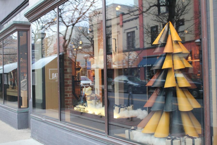 A tree made of what appears to be maize and blue leather stands on display in the side window of Shinola Detroits Ann Arbor location.