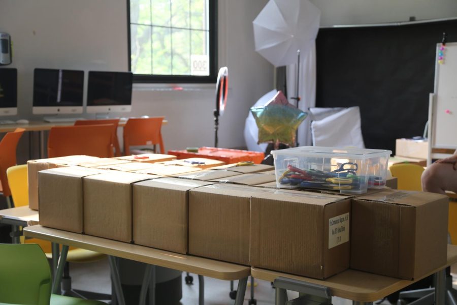 Boxes filled with the senior edition of the Communicator Magazine sit on a table ready to be opened by the print Editors-in-Chiefs.