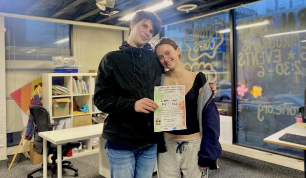 Elsa Pasquariello and Peyton Kifer hold up the poster for the upcoming Teen Voice event.