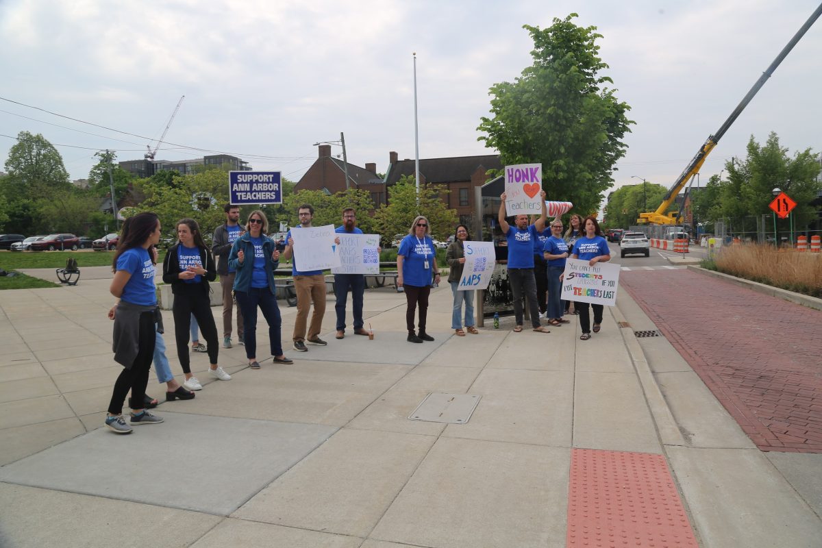 Teachers stand outside Community High School, holding up signs to gain support for AAPS teachers.