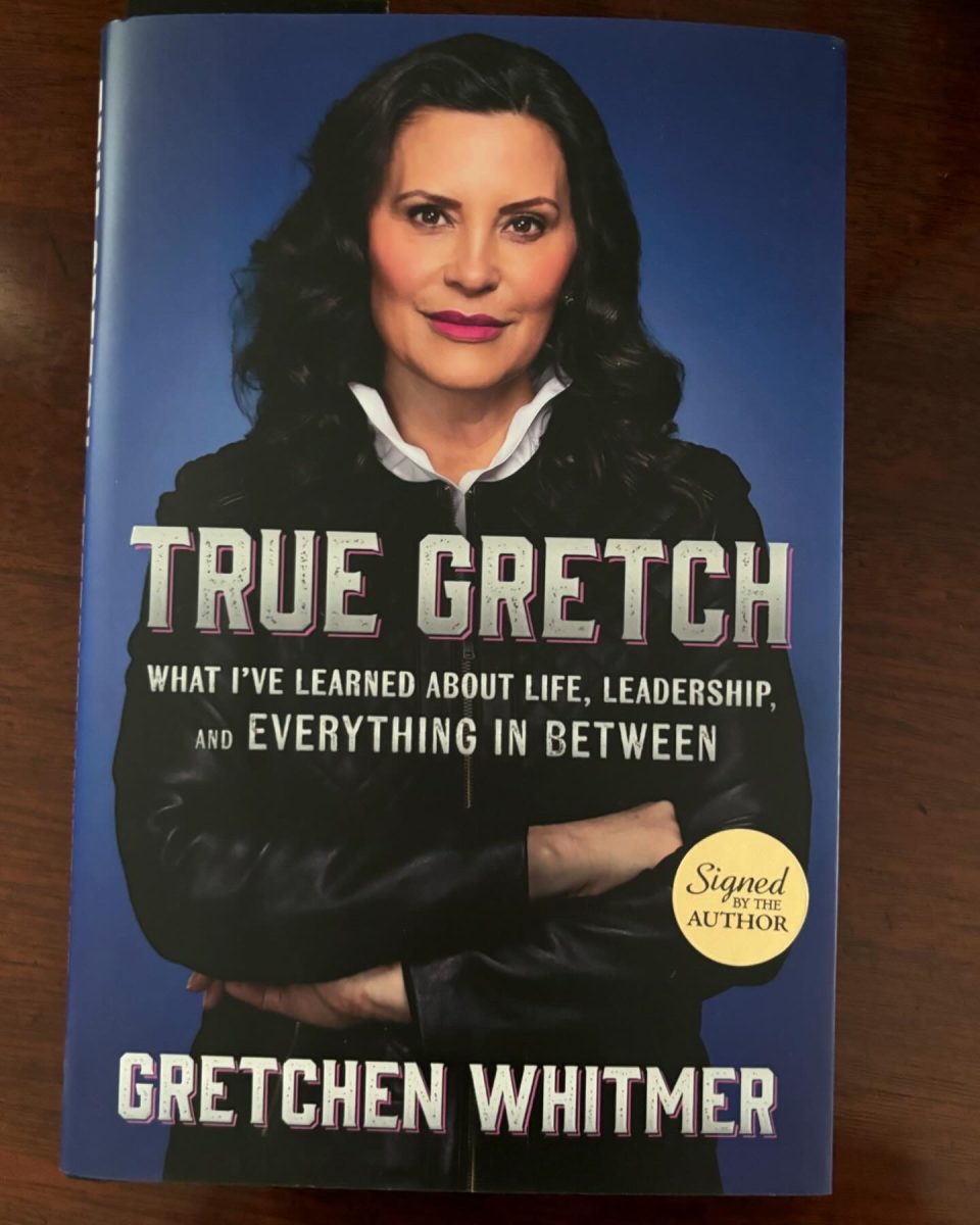 A signed copy of “True Gretch: What I've Learned About Life, Leadership, and Everything in Between” sits on a table.