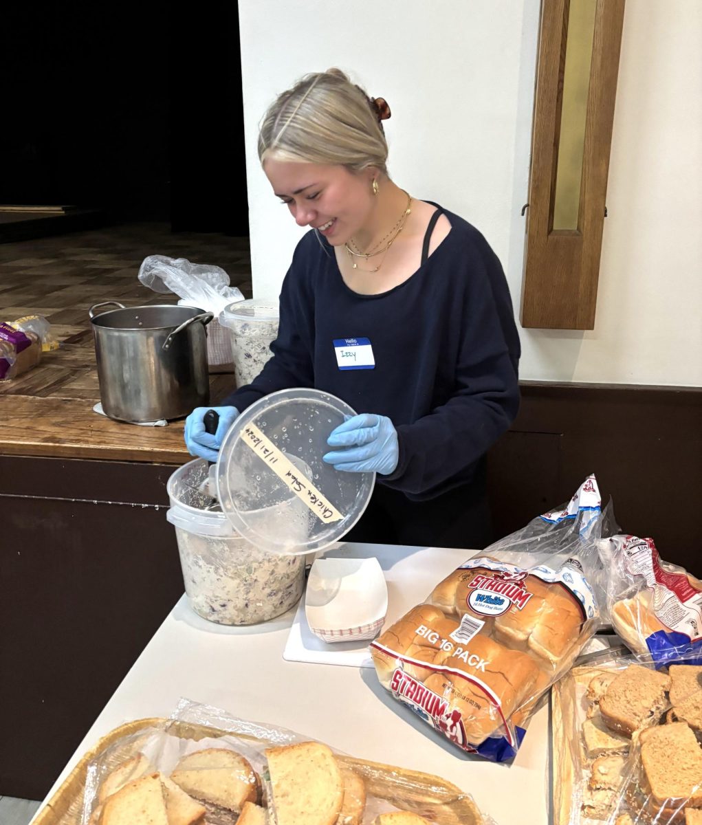 Izzy Santiago serving chicken salad sandwiches and hotdogs at St. Andrews Breakfast Program. 