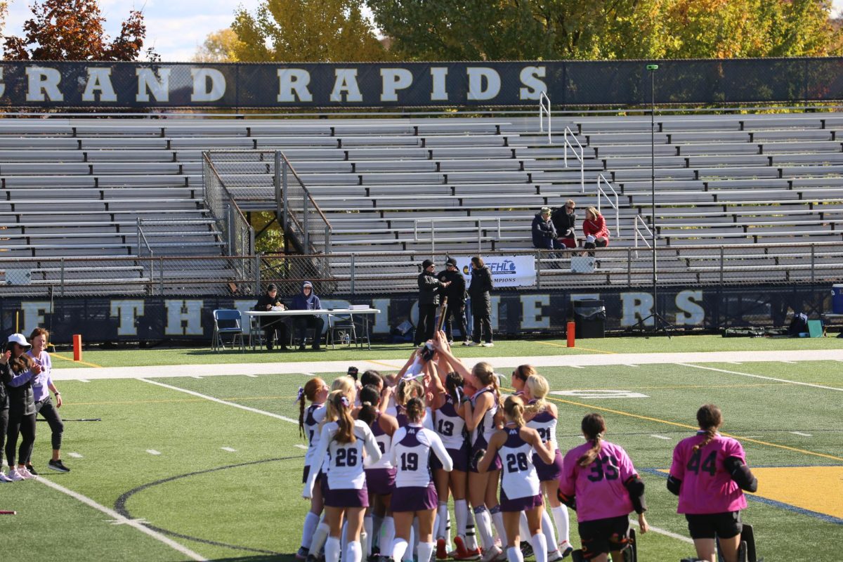 Pioneer's field hockey team celebrates their third consecutive win with their trophy.