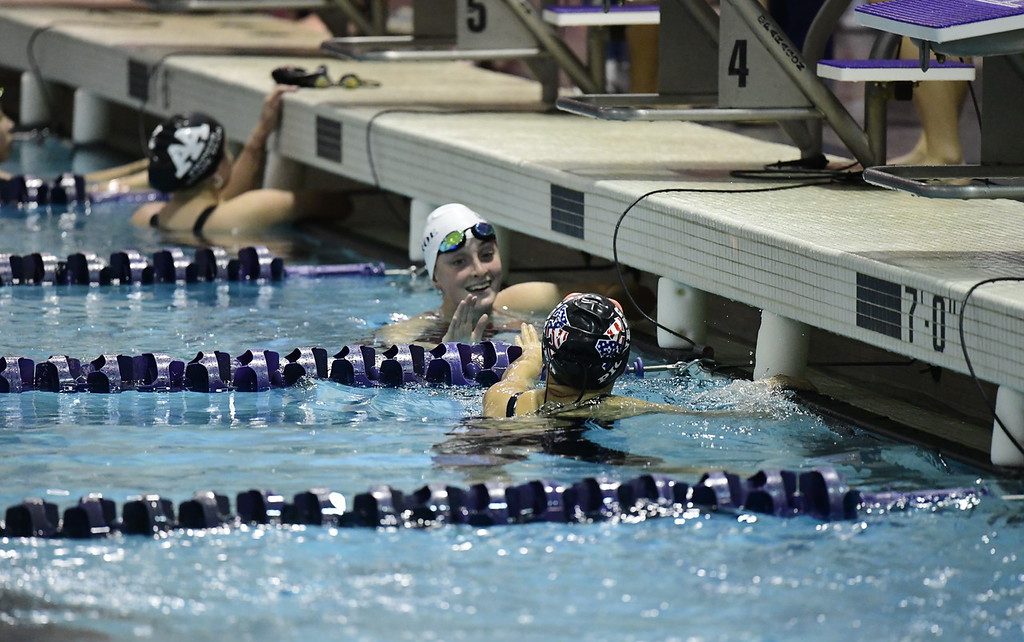 Sophomore Suryn Lee high fives Monroe swimmer after her race.