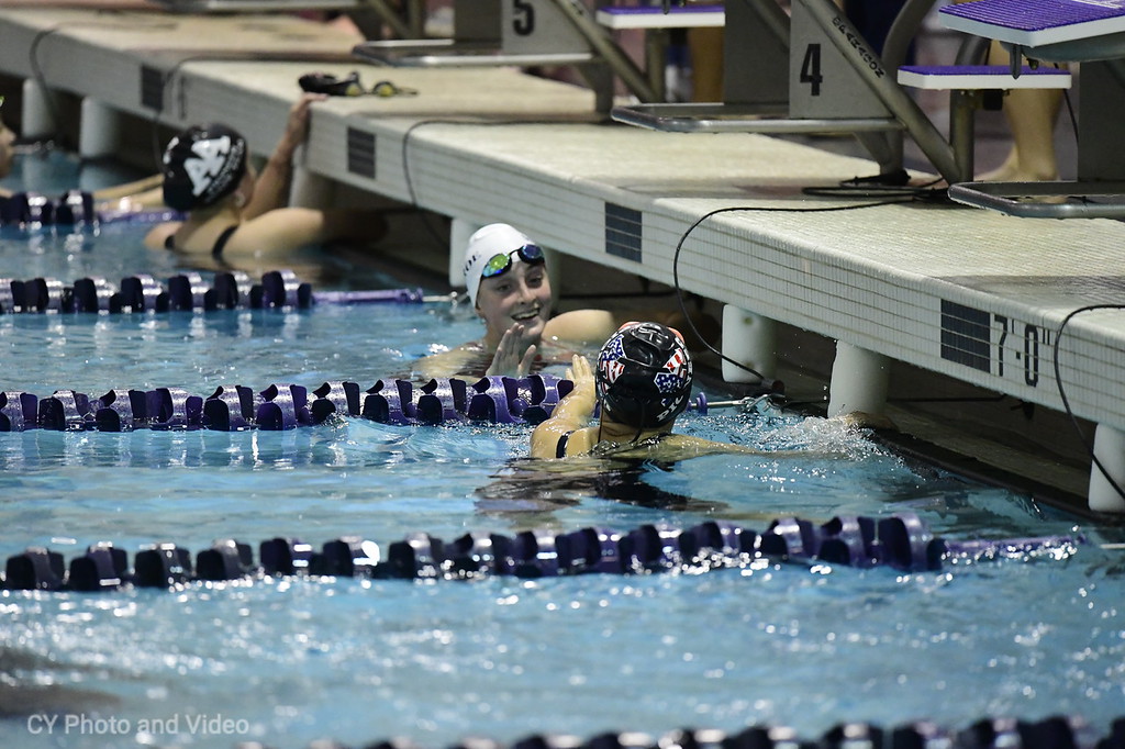 Sophomore Suryn Lee high fives Monroe swimmer after her race.