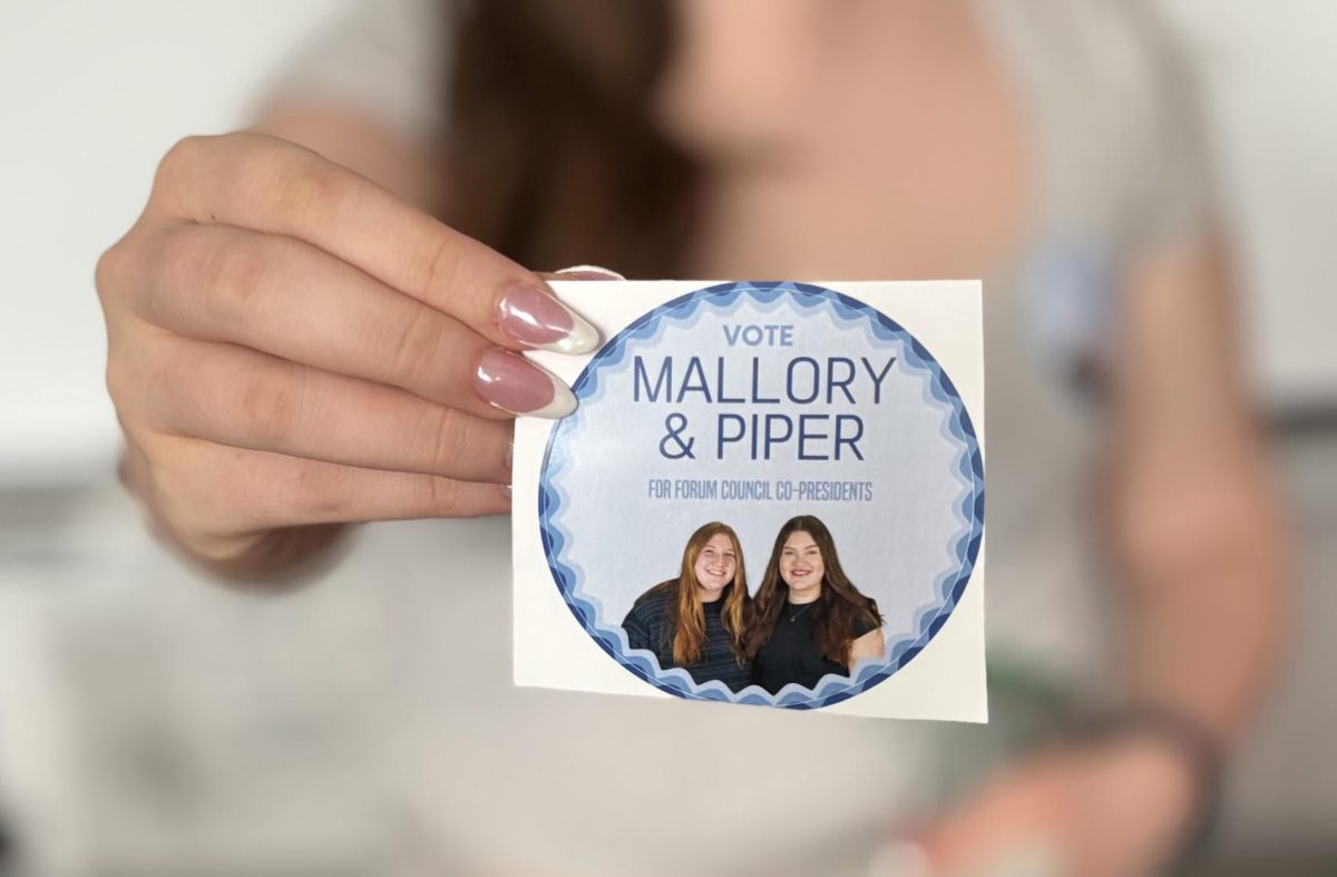 Mallory Towers and Piper Cooke, two of the FOCO co-presidents candidates, show off their give-away stickers. 