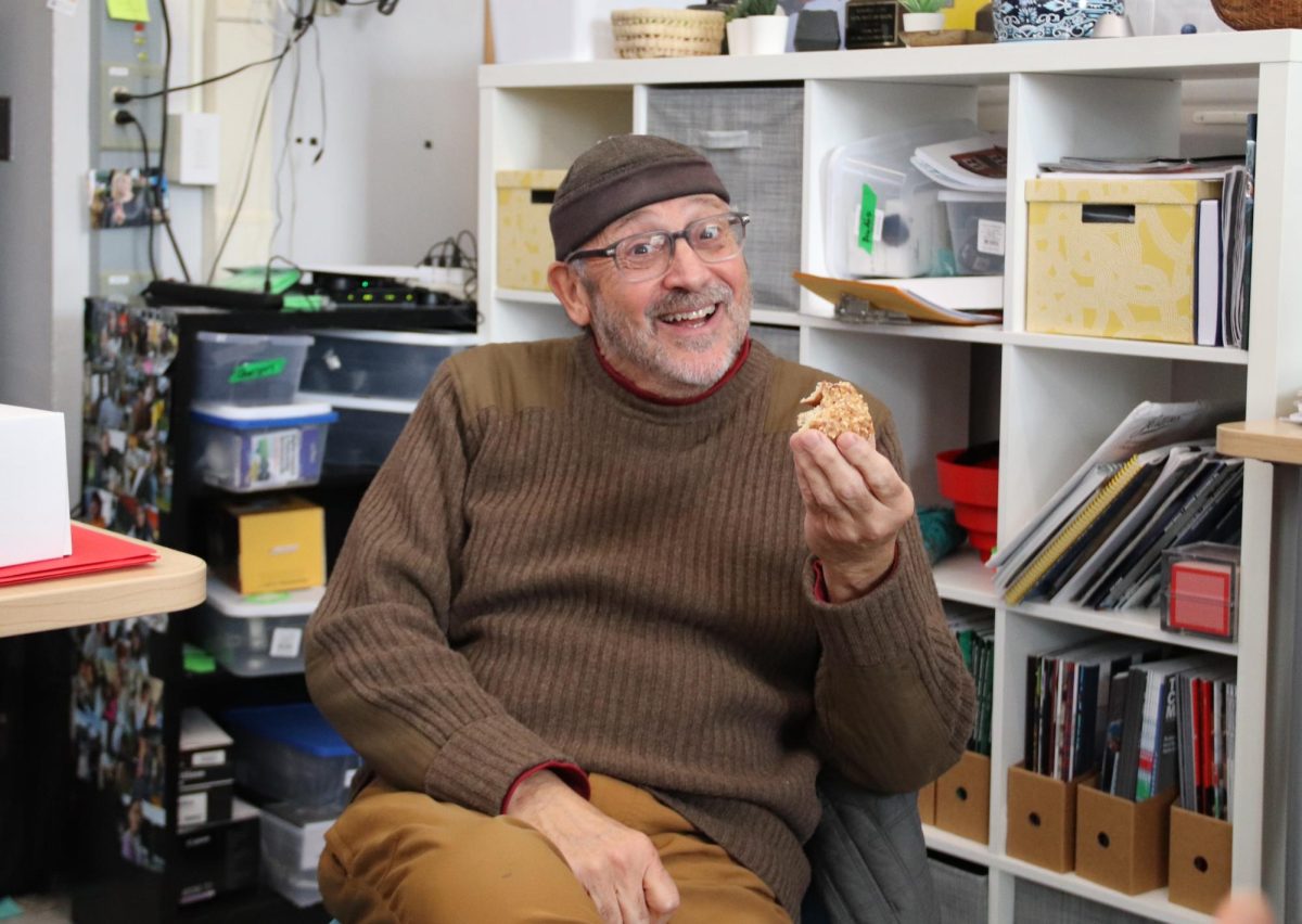 Steve Coron enjoys a peanut Washtenaw Dairy donut he sent a student to purchase from Sparrow Market. Coron was kind enough to buy donuts for the block four journalism class students as a special treat. Despite concerns from his wife about the safety of his credit card, Steve trusts some of his students to buy them. "My wife says, Why are you buying donuts for these kids all the time? And I say, because I love to feed the babies," Coron said. "If you put your trust in teenagers, it's always a crapshoot, isn't it? But I know who to trust now."