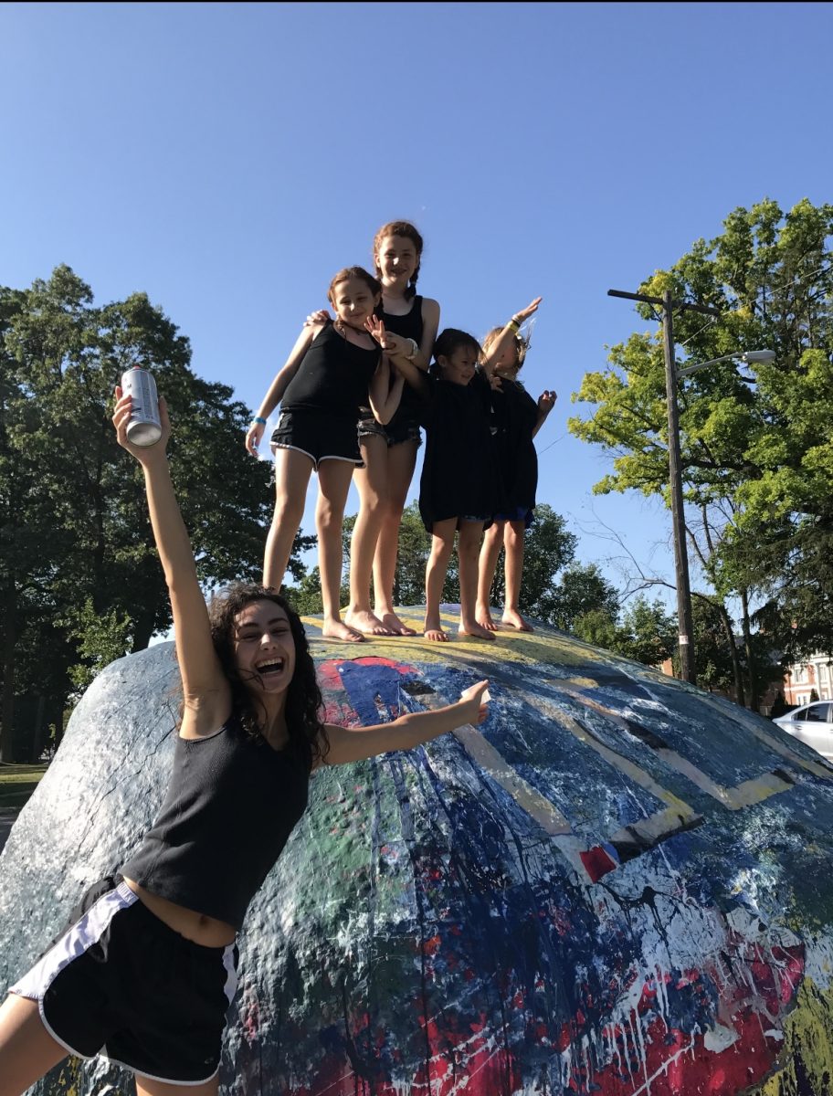 Kennedy McDonald and her sisters pose on top of "the rock," a beloved Ann Arbor landmark. 