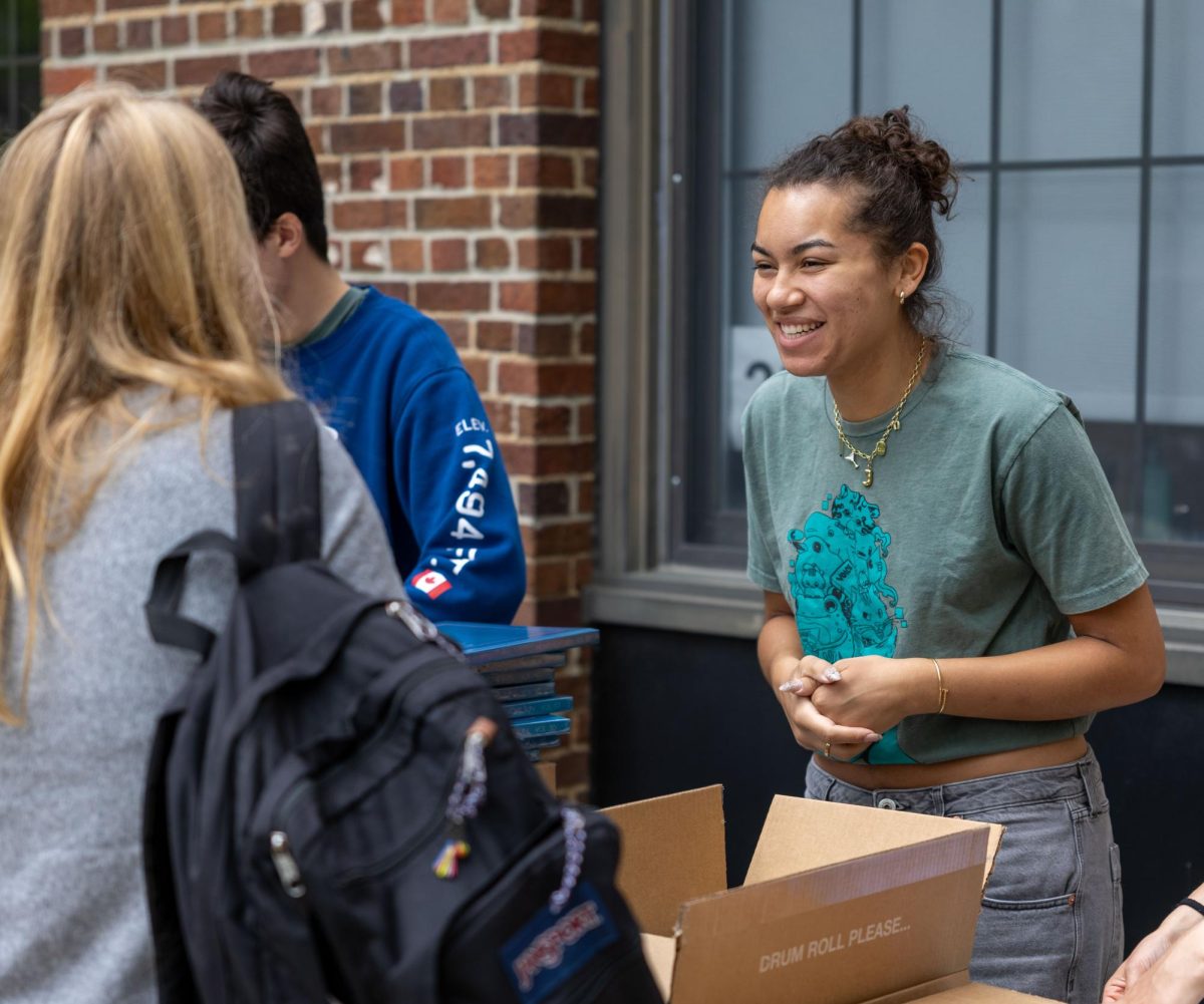 Senior yearbook editor Jacqueline Boynton chats with her classmates while handing out yearbooks. For Boynton, this is the very last time she will distribute and sign yearbooks, and this was the perfect way to kick off her last week at CHS.