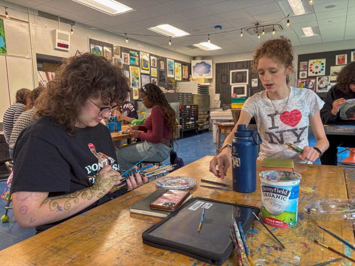 Finn Carpenter and Tiffinny Moutardier sort through paintbrushes during their Painting and Color Theory class. The two were assigned to remove watercolor brushes from a pile of regular paintbrushes so that they wouldn't be destroyed by acrylic paint. "I am really looking forward to the color theory part of this painting class," Carpenter said. "It is so interesting how many different colors can come together to create an entirely different color."