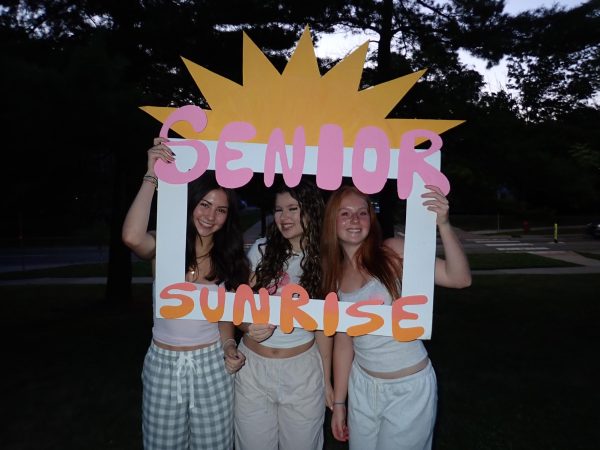 Seniors Paige Plavnick, Olivia Kreger and Maggie Lamb pose with the "Senior Sunrise" sign. 