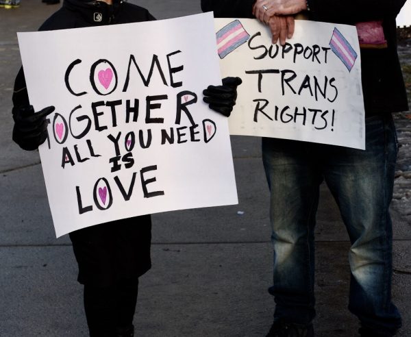 A boy and his father hold signs supporting the rights of trans and LGBTQ+ people. Although marriage is now allowed nationwide for gay couples, most people in those communities are discriminated against.
