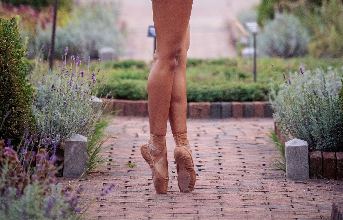 A local highschool ballerina flaunts her skin-tone pointe shoes for a photoshoot.