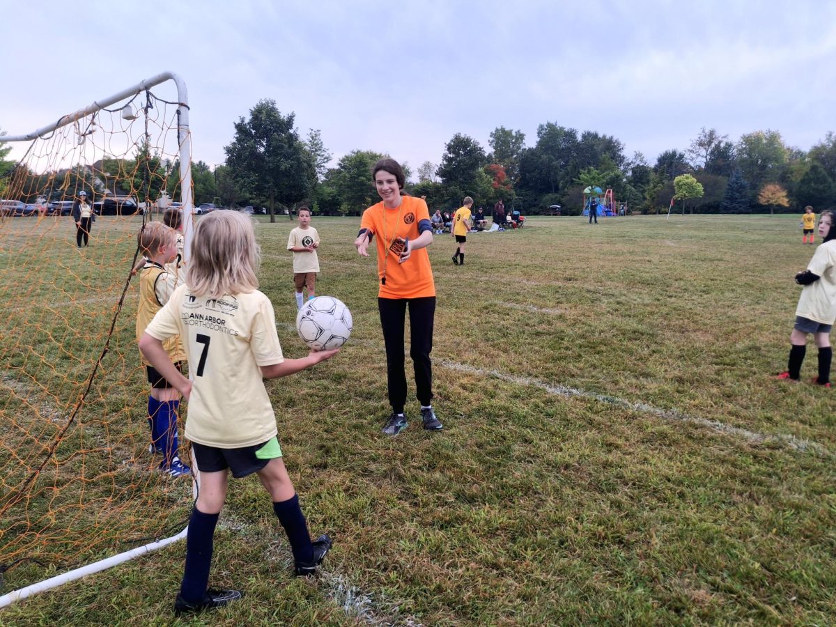 Violet Selcer receives the ball from a player to set up a goal kick. She had run back and forth on the field, calling out throw-ins, corner kicks, and goal kicks. "I'm mostly here for saftey," Selcer said. "And then everyone having fun and the rules."