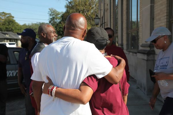 Friends and family of victims of a homecoming shooting embrace in downtown Leland, Miss., Saturday, Oct. 11, 2025.
