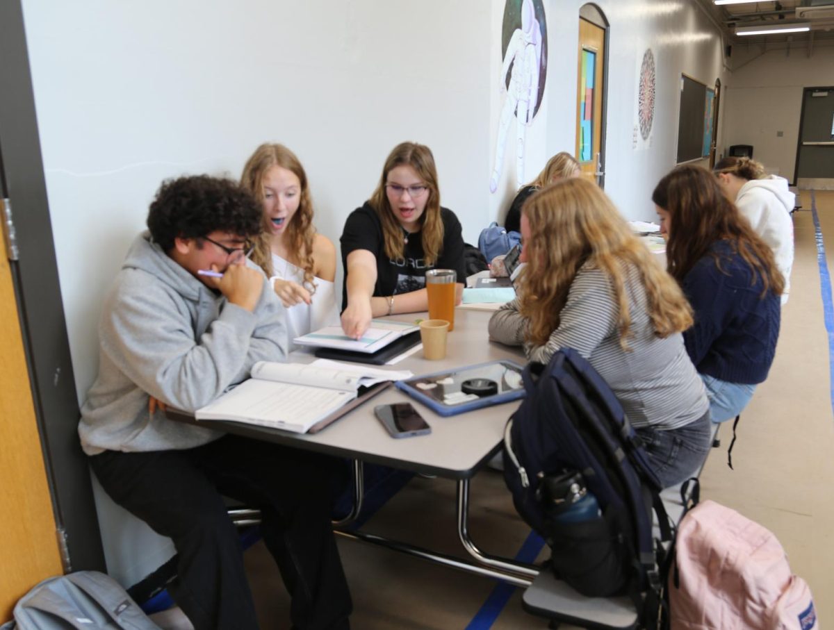 Rose Hood, Tessa Aprea, and Jules Pashturro sit at the third floor tables while trying to work out a problem in Aprea's Algebra 2 notebook. They often find themselves stuck, so working through the problems together is helpful. "Being able to work through the questions with my friends helps so much," Aprea says. "It helps me better understand the questions."