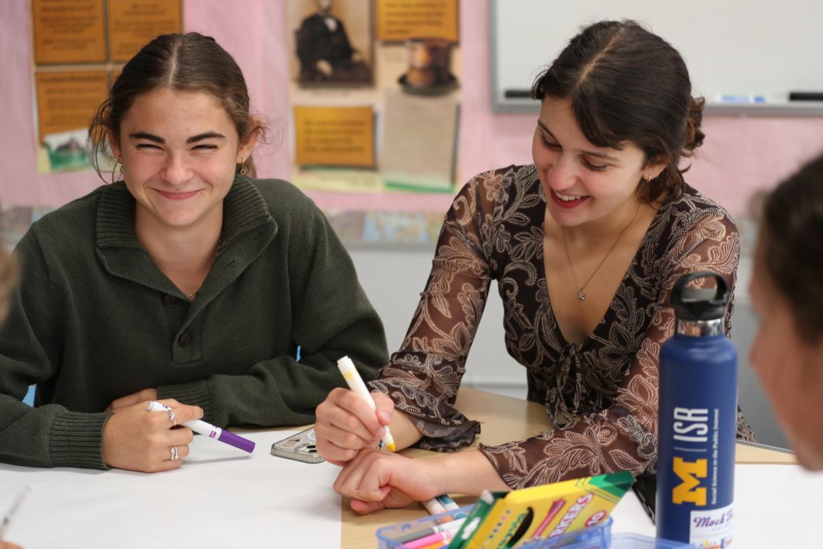 Willow Rosenfeld and Isla Tharp work on designing a sign for the Halloween dance. They were part of Forum Council's decorations committee when the project was assigned. "The atmosphere in FOCO was really fun today because everyone was working hard to get ready for the dance," Rosenfeld said. "It feels like we're working well together as a council, and I'm excited for the dance!"