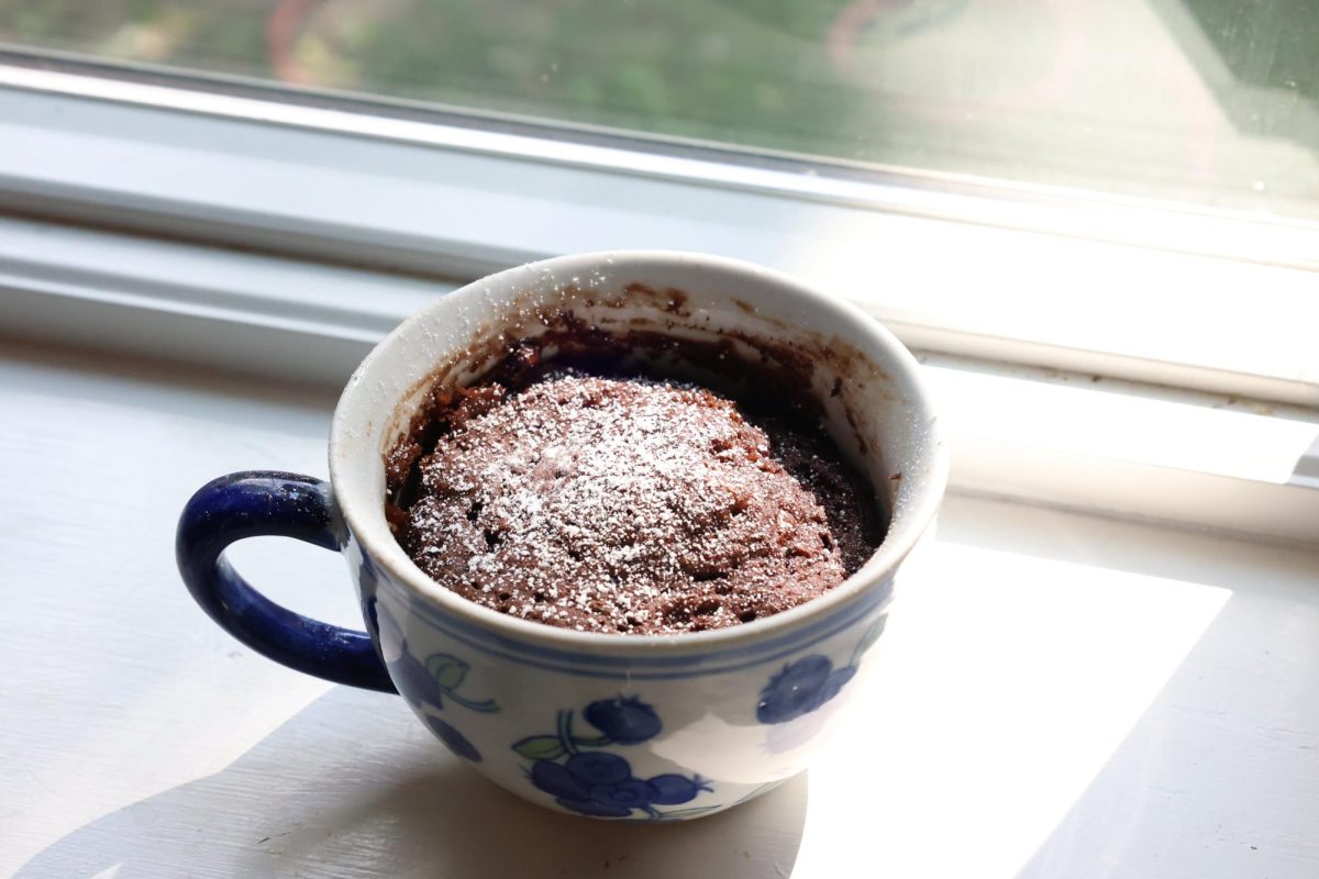 A delicious chocolate mug cake sits in a windowsill, waiting to be devoured.
