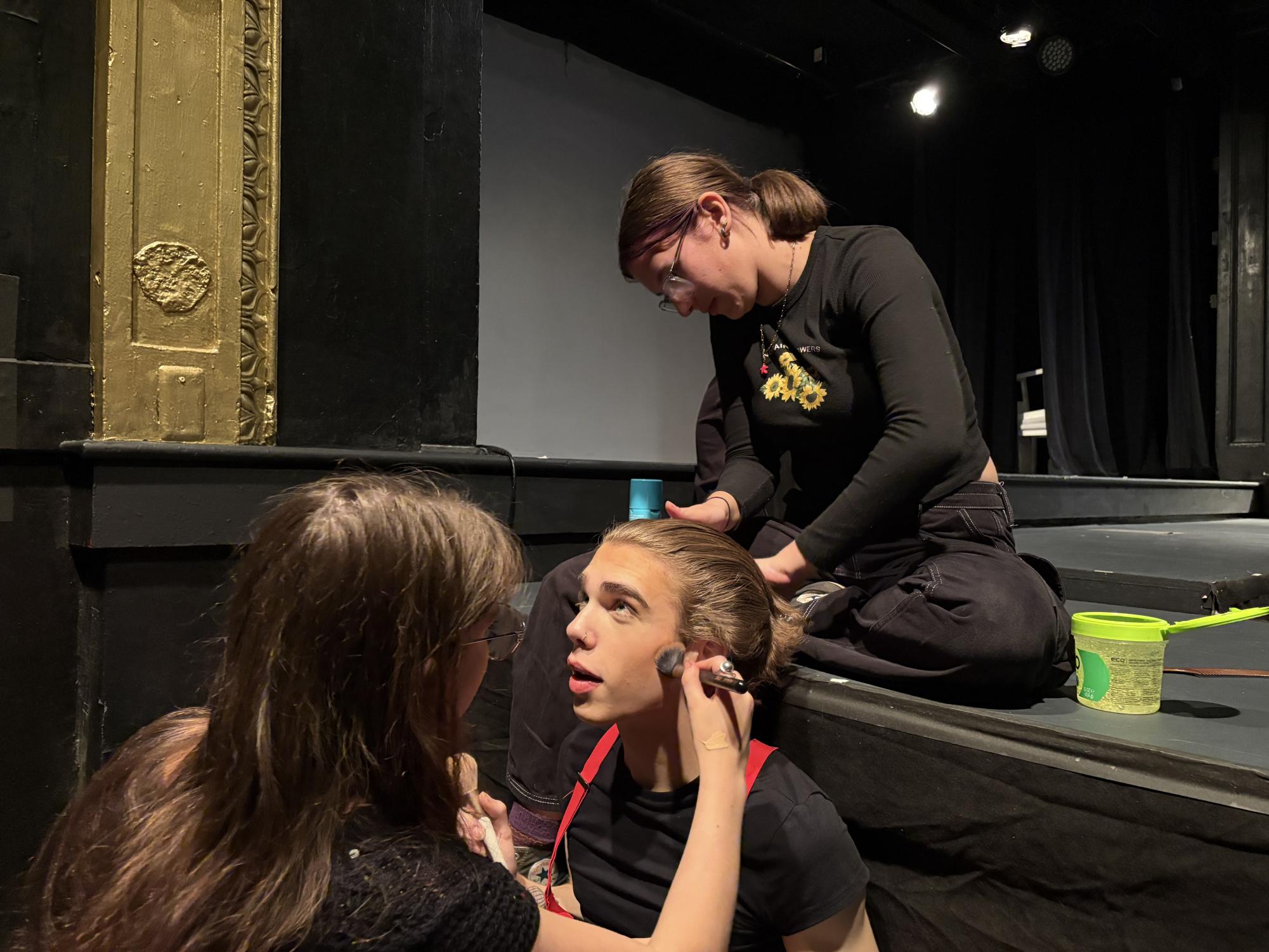Venus Stolerow (right) and Aria Rosenfeld (left) work on Ronan Laporte's (middle) hair moments before a show began.