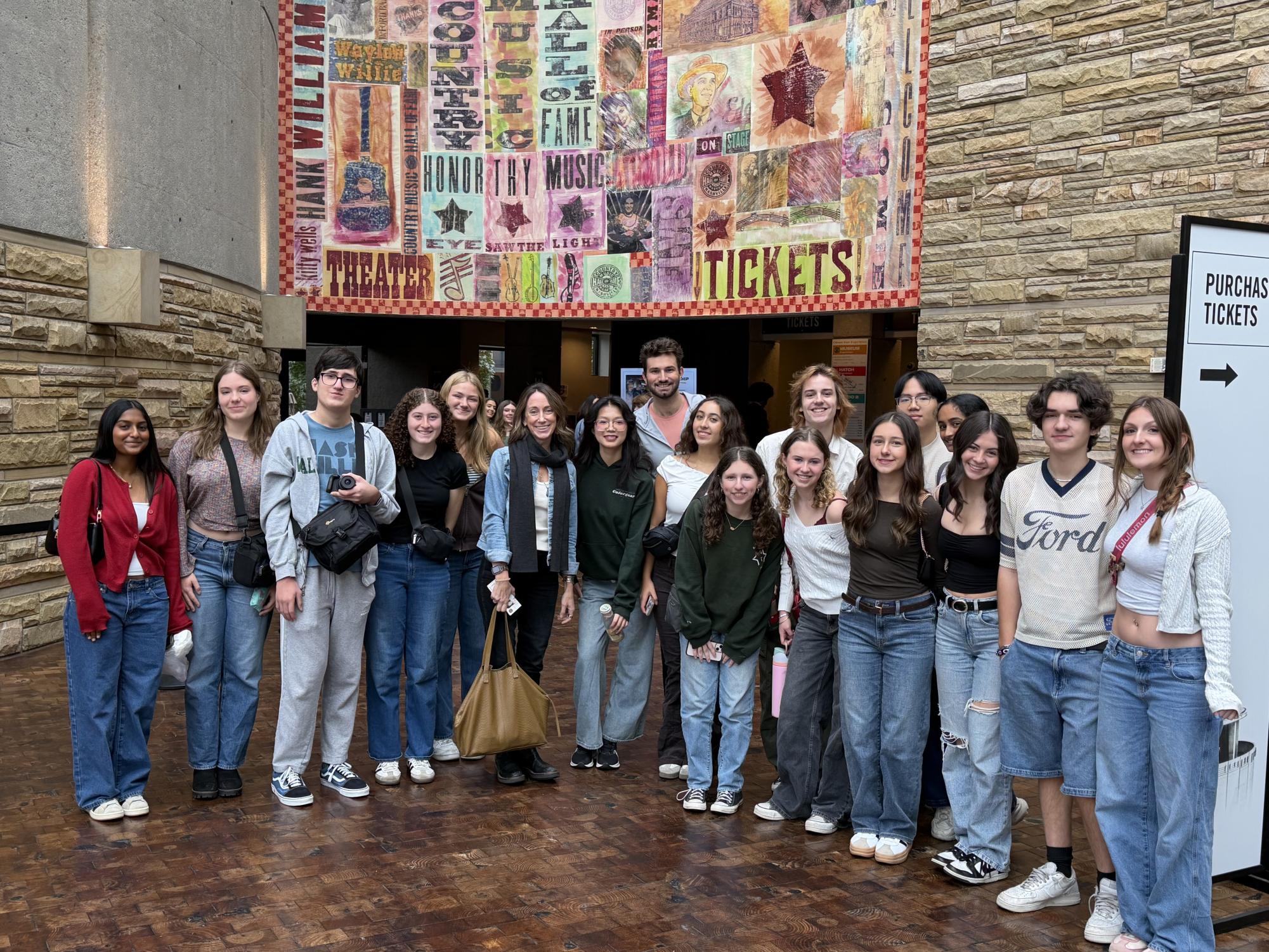 Students stand in front of museum entrance before going in.
