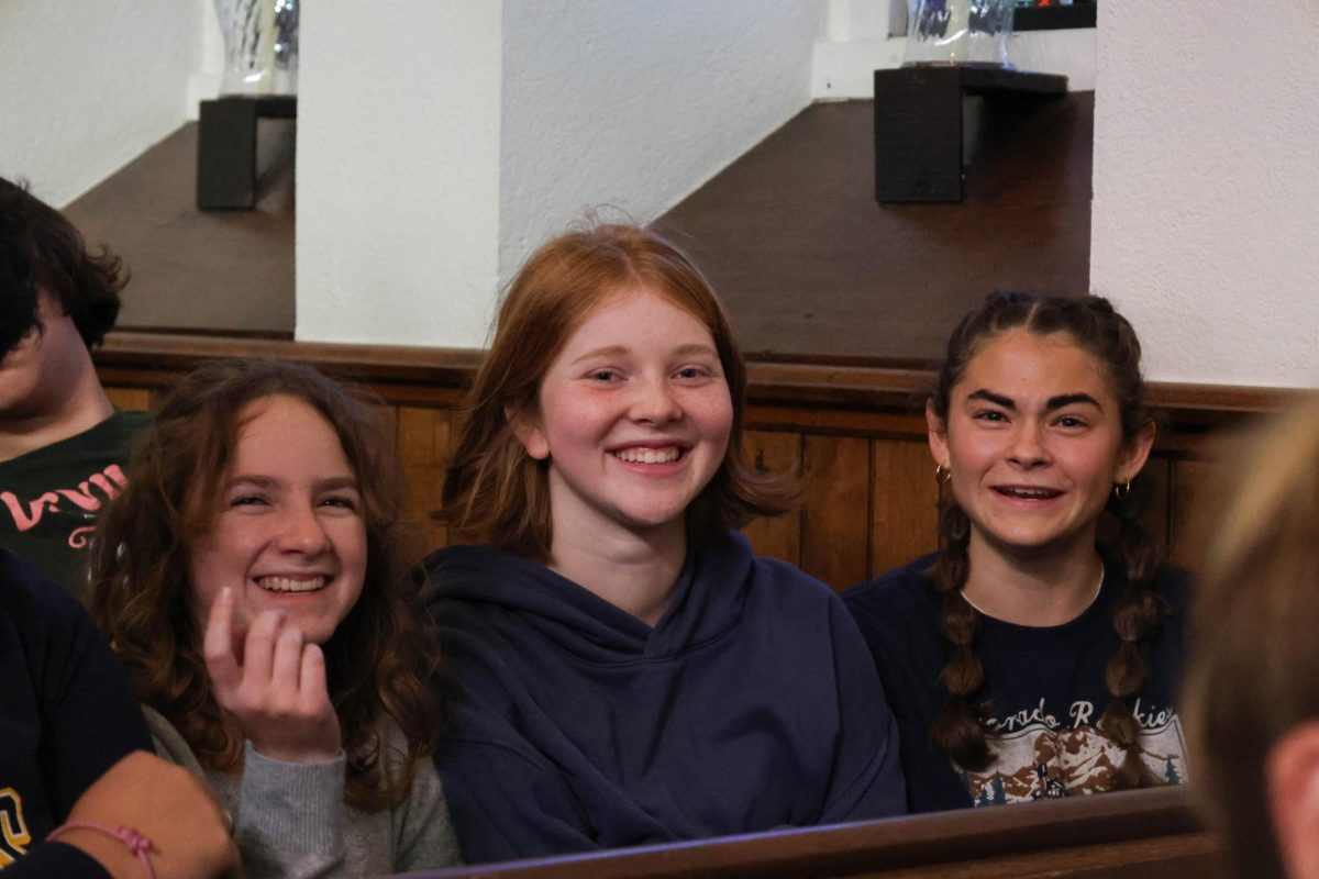 Lena Bible, Lila Sarnecki and Isla Tharp sit in St. Andrews during the Food Gatherers opening ceremony. 
