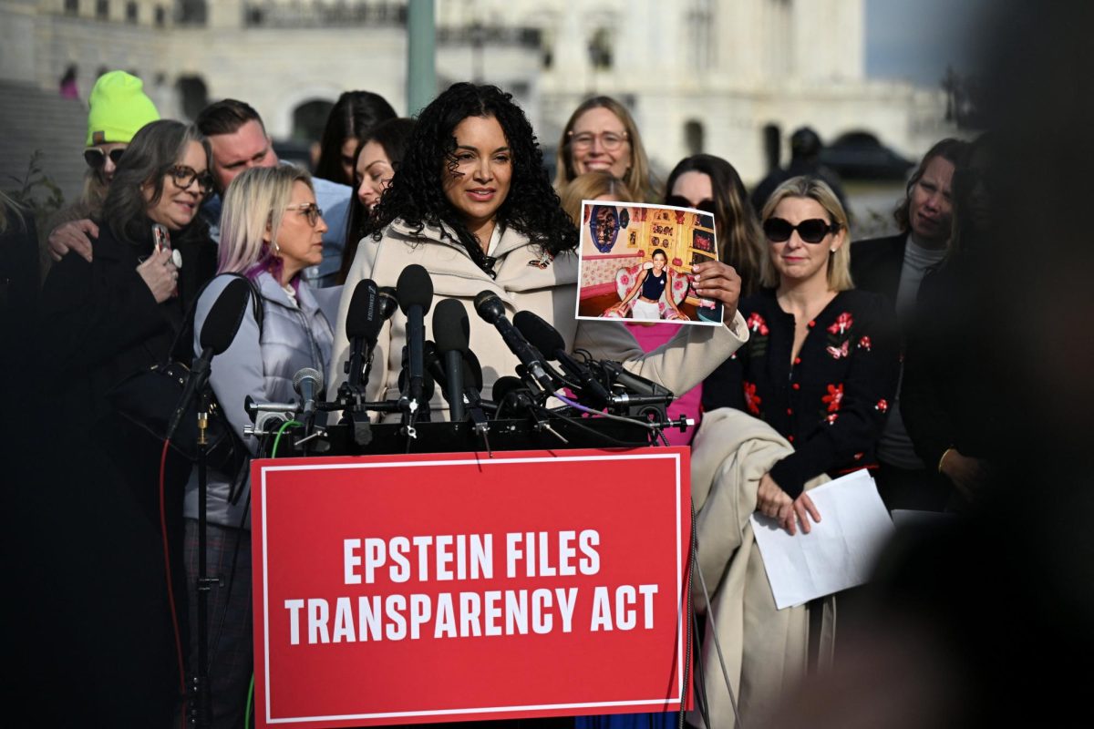 Survivor Lisa Phillips holds up her picture as she speaks during a press conference on the Epstein Files Transparency Act ahead of a House vote on the release of files related to the late convicted sex offender Jeffrey Epstein, on Capitol Hill in Washington, D.C., U.S., November 18, 2025. REUTERS/Annabelle Gordon