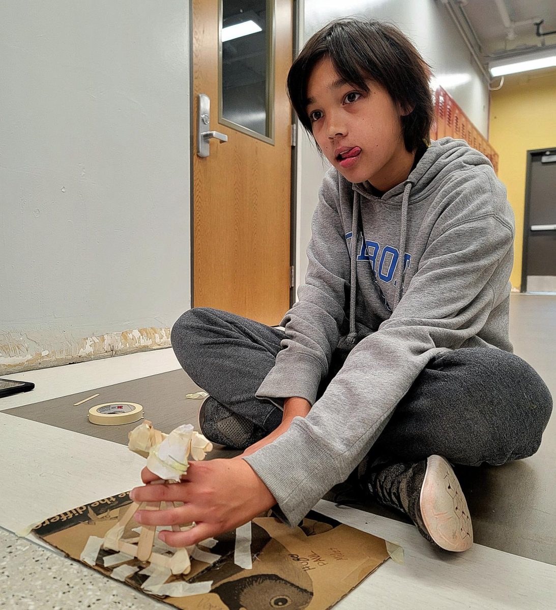 Freshman Miles Feng launches his team's rice bag across the hall with a handmade slingshot. Initially, the Engineering and Design students' team aimed to shoot the bean bag as far as possible, but this challenge required accuracy. "It sometiems doesn't feel great, but it's fine because it's not graded on quality, just research," Feng said. "It's all about iterating your designs and always trying to make things better."