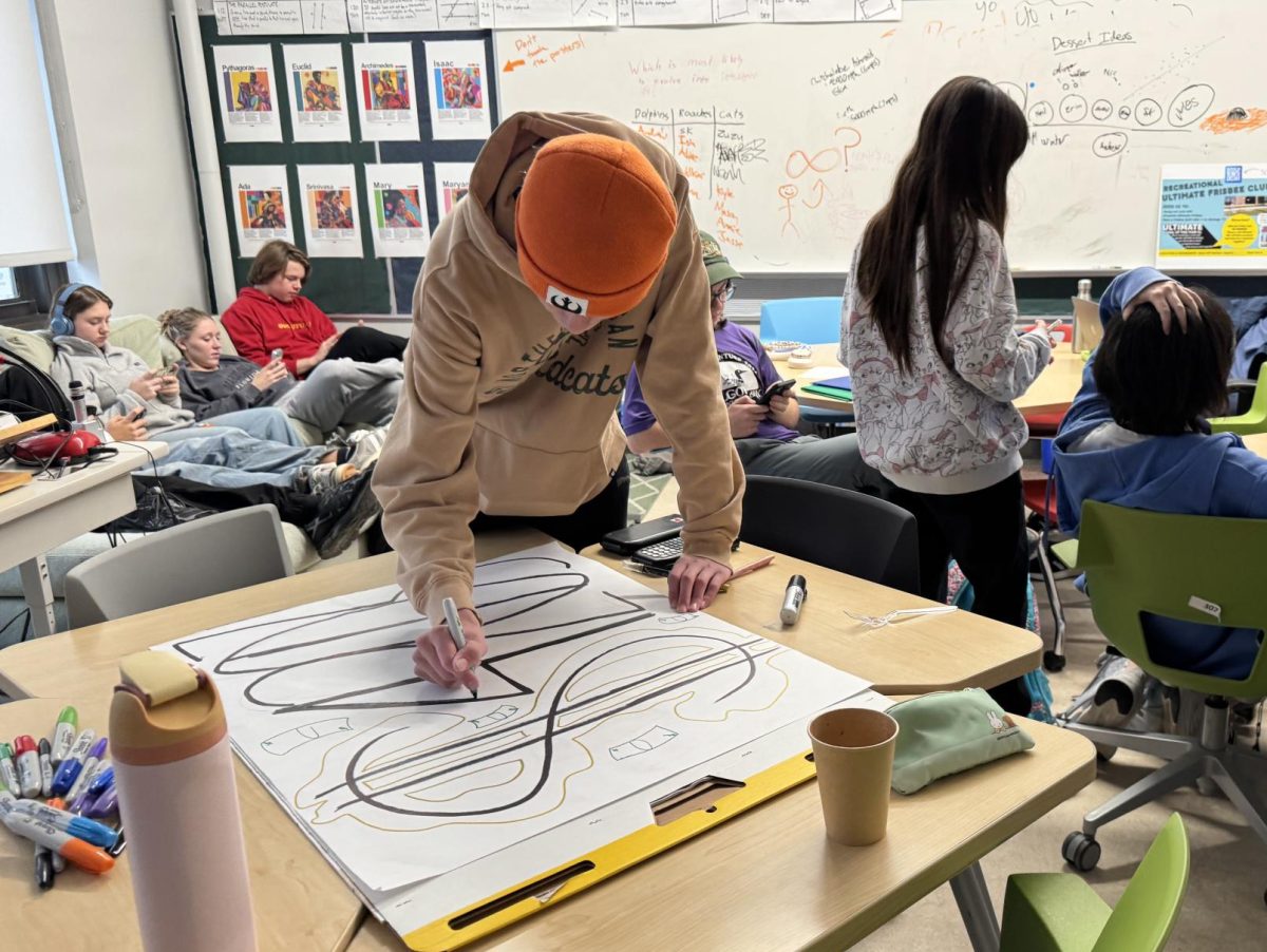 Björn Jensen draws Richmond forum sign for the Food Gatherers ceremony. Jensen loves to draw and in the past has created the Richmond forum logo that they previously put on their field day t-shirts. "I love to draw," Jensen said. "It's cool how you can create something from nothing."