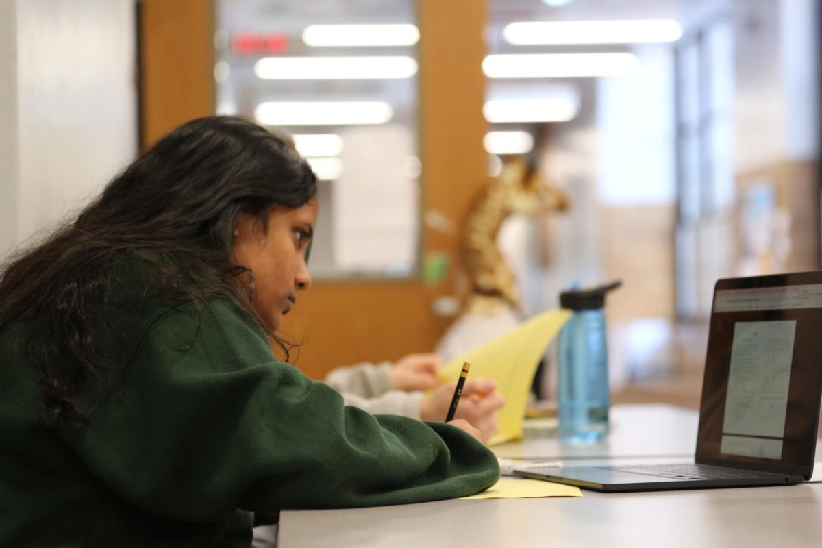 Mira Kshirsaga sits at a table in the hallway of the 3rd floor at CHS.