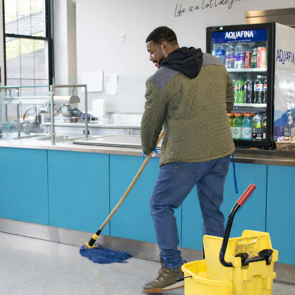Carl Tyler mops the floor of the CHS café as he converses with all who walk by. He had been strolling the second floor giving out high fives, hugs, and positive energy as he kept the halls of the school nice and clean. "The ladies in here take such good care of the kitchen," Tyler said. "I appreciate it so much."