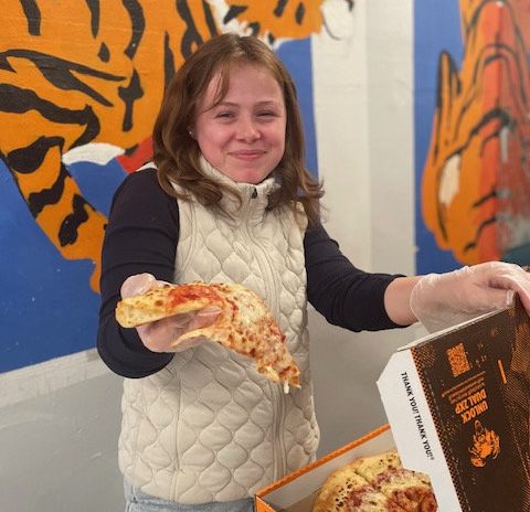 Bea Van Slembrouck hands out pizza for the Johnson forums' Food Gatherers sale. She enjoyed selling pizza to raise money for the important cause. "Fundraising for Food Gatherers is important because there are hungry children out there, and they need food," Van Slembrouck said. "With what the Trump administration just did, we need to raise money for children."