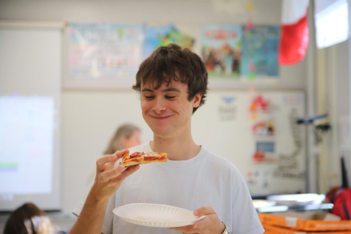 Augustus Kaschube takes a bite out of his slice of pizza. Kaschube is in the Mosher Forum and they got pizza for forum lunch. "I really like when my forum can have food like this," Kaschube said. "It's nice when we can all sit together, eat and talk."