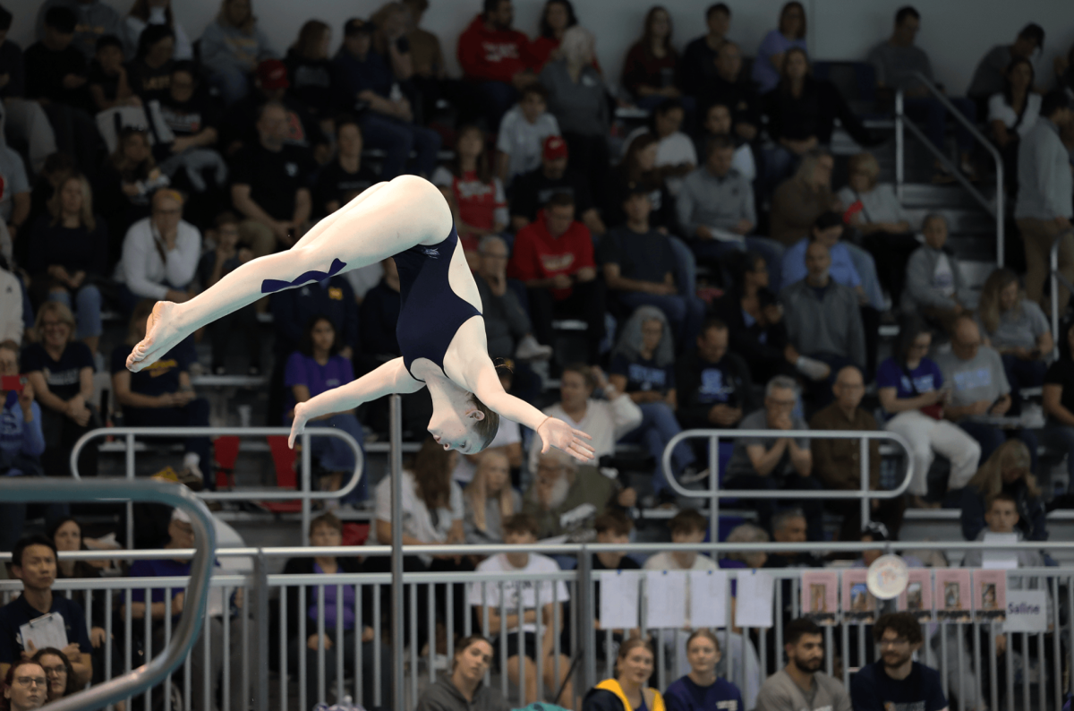 Sylvia Biermann flips off a diving board during a meet. Biermann dives for Skyline High School.