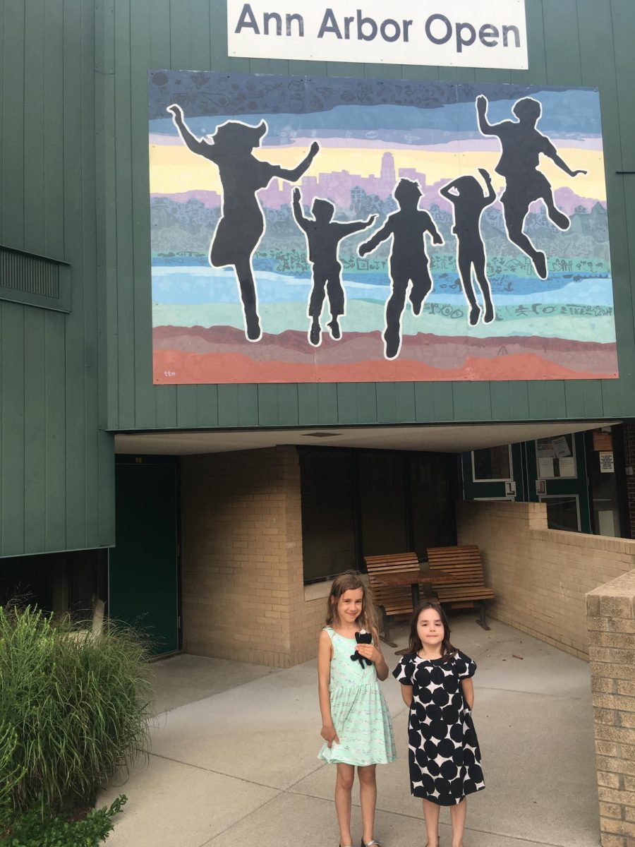 In fourth grade, Zia Walker (left) stands outside of Ann Arbor Open School with her sister.